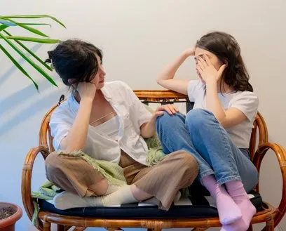 Two young people talking, seated together